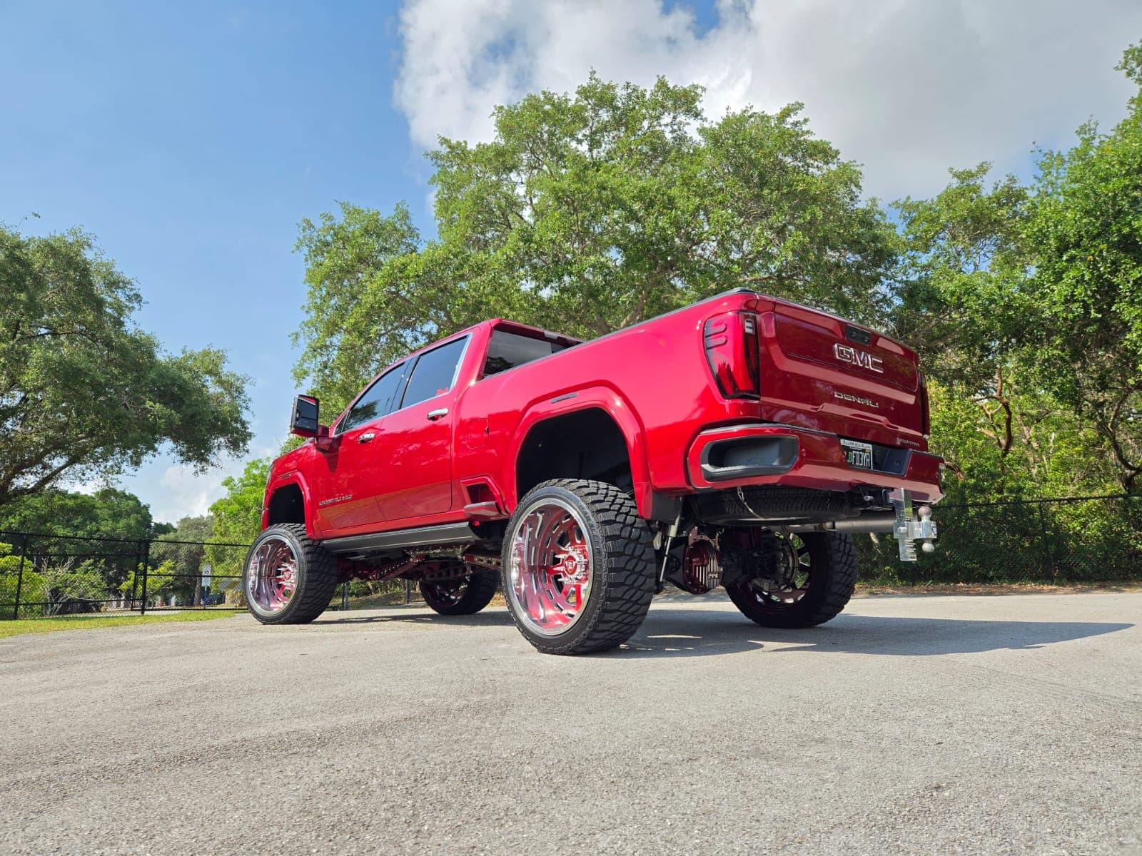 Wide rear view of a lifted red GMC Denali showing its custom forged Diesel Wheels