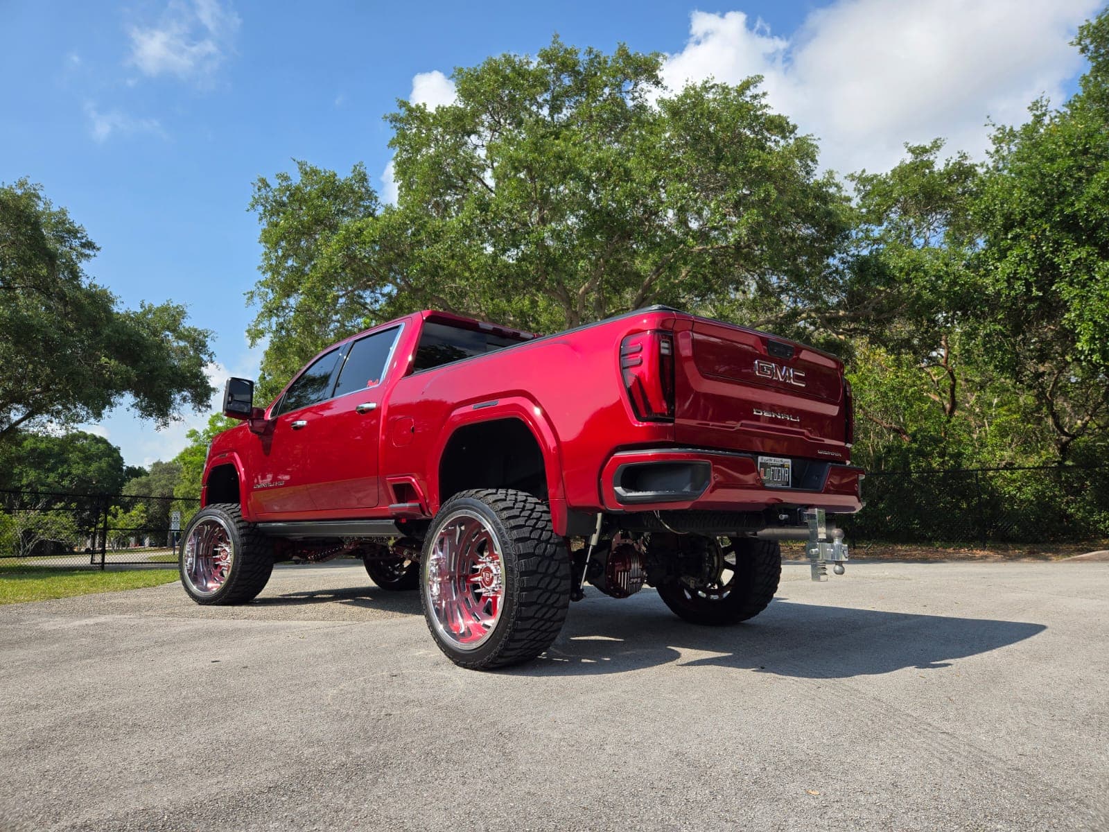 Lifted red GMC Denali on custom forged Diesel Wheels viewed from the rear